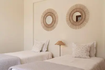 two beds in a bedroom with mirrors on the wall at Villa Areal Porto Santo - By An Island Apart in Porto Santo