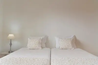 two beds in a bedroom with white walls and pillows at Villa Areal Porto Santo - By An Island Apart in Porto Santo