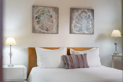 a bedroom with a bed with two pictures on the wall at Villa Areal Porto Santo - By An Island Apart in Porto Santo