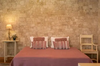 a bed with two pillows and a brick wall at Villa Areal Porto Santo - By An Island Apart in Porto Santo