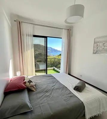 a bedroom with a large bed with a large window at Santa Catarina by Olá Madeira in Funchal