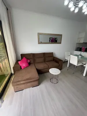 a living room with a brown couch and a table at Santa Catarina by Olá Madeira in Funchal
