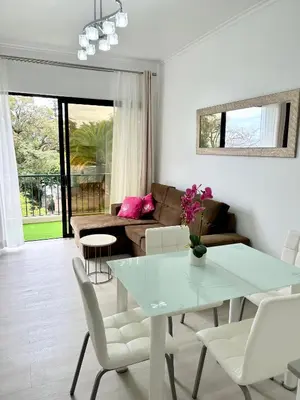 a living room with a table and a couch at Santa Catarina by Olá Madeira in Funchal