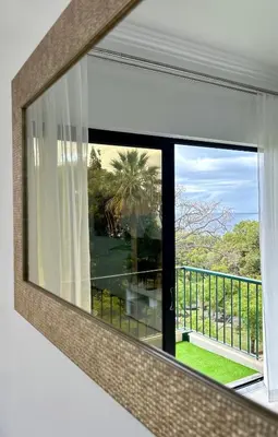 a mirror reflecting a window with a view of a balcony at Santa Catarina by Olá Madeira in Funchal