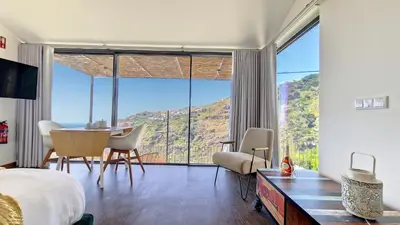 a bedroom with a bed and a table and chairs at Serenity Valley Escape by LovelyStay in Ribeira Brava