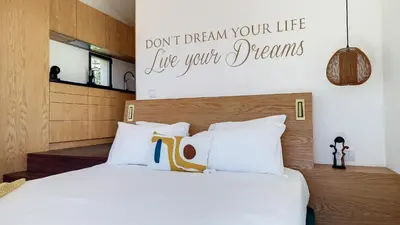 a bedroom with a bed with a sign on the wall at Serenity Valley Escape by LovelyStay in Ribeira Brava