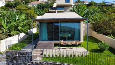 a glass house with a swing in a yard at Serenity Valley Escape by LovelyStay in Ribeira Brava