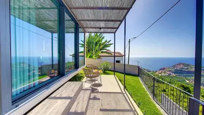 a house with a balcony with a view of the ocean at Serenity Valley Escape by LovelyStay in Ribeira Brava