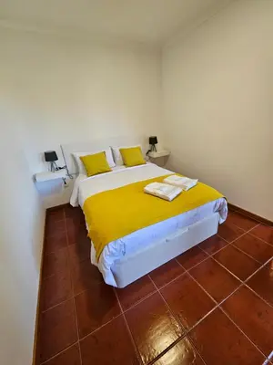 a bedroom with a bed with a yellow blanket at Apartamento Costa Norte in Porto Moniz