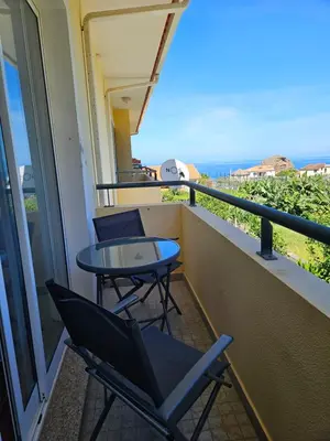 a balcony with a table and chairs and the ocean at Apartamento Costa Norte in Porto Moniz