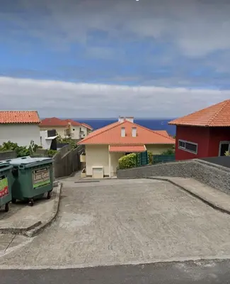 a view of a driveway with houses in the background at Apartamento Costa Norte in Porto Moniz