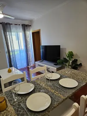 a dining room with a table and chairs with wine glasses at Apartamento Costa Norte in Porto Moniz