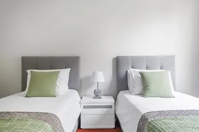 a bedroom with two beds with green and white pillows at Barreiros Serenity by Homie in Funchal