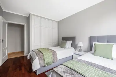 two beds in a bedroom with white walls and wood floors at Barreiros Serenity by Homie in Funchal
