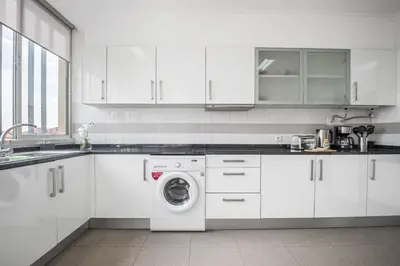 a white kitchen with a washing machine in it at Barreiros Serenity by Homie in Funchal