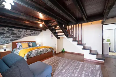 a bedroom with a bed and a staircase at Casa da Vizinha in Ponta do Sol