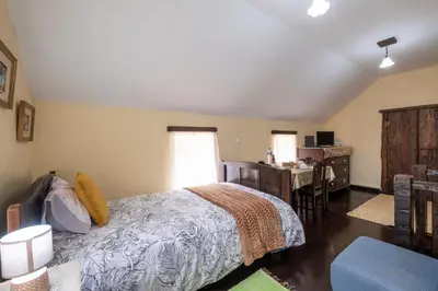 a bedroom with a bed and a desk at Casa da Vizinha in Ponta do Sol