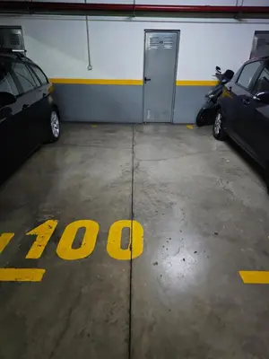 a garage with two cars parked in front of a door at Milagrosa Apartment in Caniço