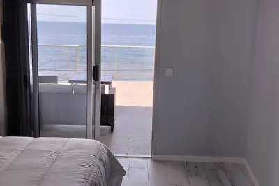 a bedroom with a view of the ocean through a door at Apt. 'A Bicuda' by The Cliff Coast Accomodation in Paul do Mar