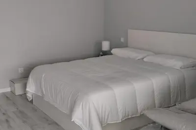 a white bed in a bedroom with a white wall at Apt. 'A Bicuda' by The Cliff Coast Accomodation in Paul do Mar