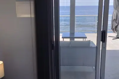 a sliding glass door with a view of the ocean at Apt. 'A Bicuda' by The Cliff Coast Accomodation in Paul do Mar