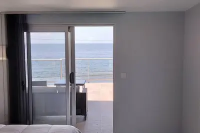 a bedroom with a view of the ocean through a sliding glass door at Apt. 'A Bicuda' by The Cliff Coast Accomodation in Paul do Mar