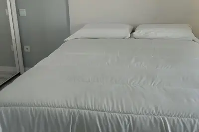 a white bed with two pillows on top of it at Apt. 'A Bicuda' by The Cliff Coast Accomodation in Paul do Mar