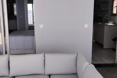 a white couch in a living room with a mirror at Apt. 'A Bicuda' by The Cliff Coast Accomodation in Paul do Mar