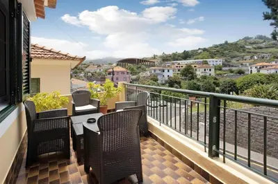 a balcony with chairs and a table with a view at Casa do tio Inácio in Santana