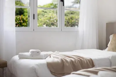 two white beds with towels on them in a bedroom at Casa do tio Inácio in Santana