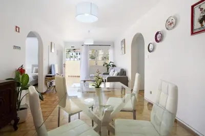 a living room with a glass table and white chairs at Casa do tio Inácio in Santana
