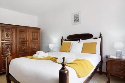 a bedroom with a bed with a yellow blanket on it at Casa do tio Inácio in Santana