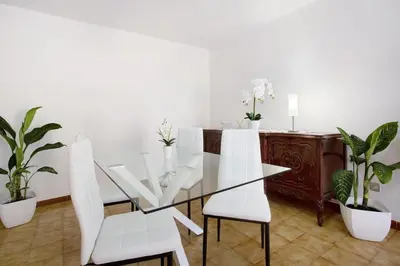 a dining room with a glass table and white chairs at Casa do tio Inácio in Santana