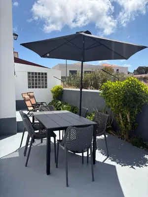 a table and chairs with an umbrella on a patio at Beach Relax Apartment in Porto Santo