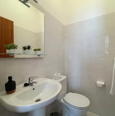 a white bathroom with a toilet and a sink at Beach Relax Apartment in Porto Santo