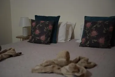 a bed with a pile of towel on it at Serenity Apartment - Free Parking in Santa Cruz