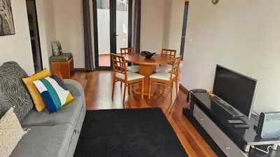 a living room with a couch and a table and a television at Serenity Apartment - Free Parking in Santa Cruz