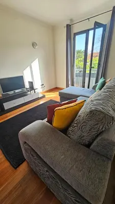 a living room with a couch and a large window at Serenity Apartment - Free Parking in Santa Cruz