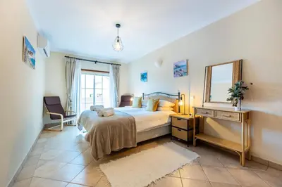 a bedroom with a large bed and a mirror at Casa Keira in Luz