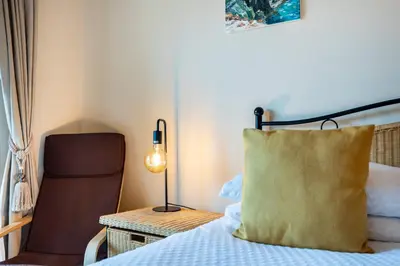 a bedroom with a bed with a pillow and a chair at Casa Keira in Luz
