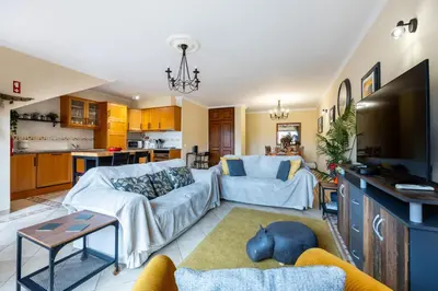 a living room with a couch and a tv at Casa Keira in Luz