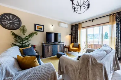 a living room with two couches and a tv at Casa Keira in Luz