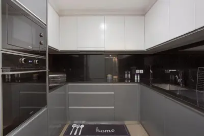 a kitchen with white cabinets and a black appliance at Alegria Dream Home in Funchal