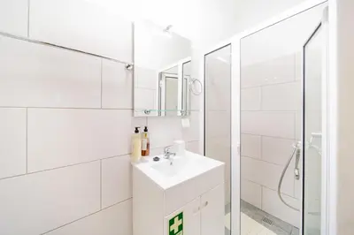 a white bathroom with a sink and a shower at Casa na Ilha I in Funchal