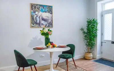 a dining room with a white table and green chairs at Casa na Ilha I in Funchal