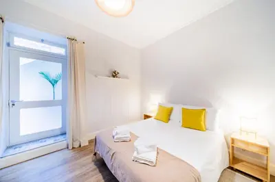 a bedroom with a bed with yellow pillows and a window at Casa na Ilha II in Funchal