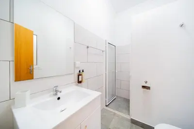 a white bathroom with a sink and a shower at Casa na Ilha II in Funchal