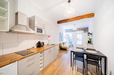 a kitchen with white cabinets and a table with chairs at Casa na Ilha II in Funchal