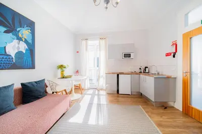 a living room with a pink couch and a kitchen at Casa na Ilha III in Funchal