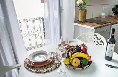a table with a plate of fruit and a bottle of wine at Casa na Ilha III in Funchal